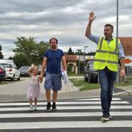 Poslanec spremlja otroka čez prehod za pešce